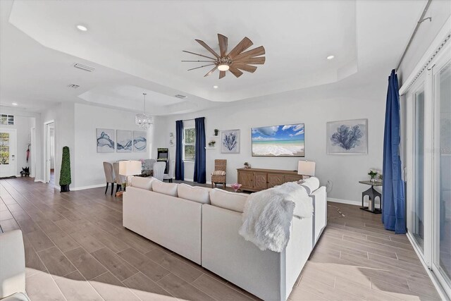 14381 Heritage Landing Blvd, Punta Gorda, FL 33955 - living area with baseboards, wood finish floors, a tray ceiling, recessed lighting, and ceiling fan with notable chandelier