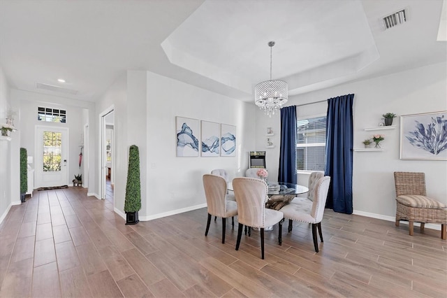 14381 Heritage Landing Blvd, Punta Gorda, FL 33955 - dining area with a raised ceiling, light wood-type flooring, visible vents, and a chandelier