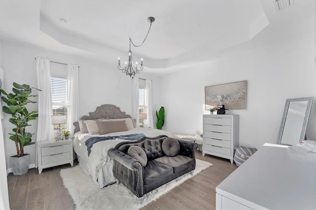 14381 Heritage Landing Blvd, Punta Gorda, FL 33955 - bedroom with visible vents, light wood-type flooring, a raised ceiling, and an inviting chandelier