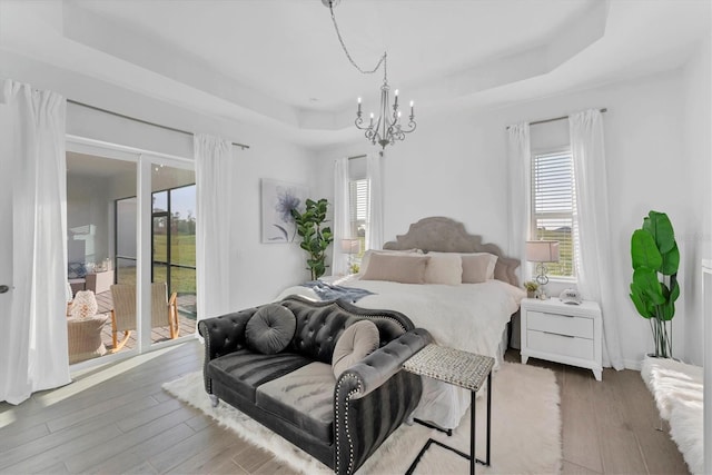 14381 Heritage Landing Blvd, Punta Gorda, FL 33955 - bedroom featuring a raised ceiling, multiple windows, access to exterior, and wood finished floors