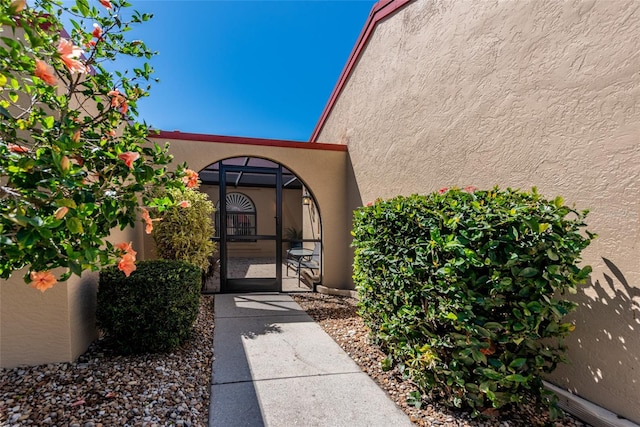 doorway to property with a gate and stucco siding