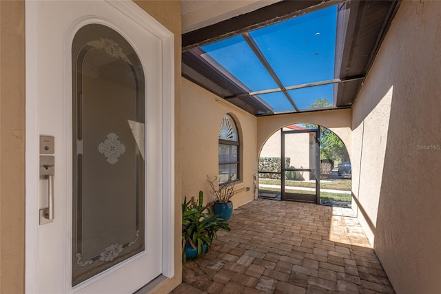 view of patio featuring glass enclosure