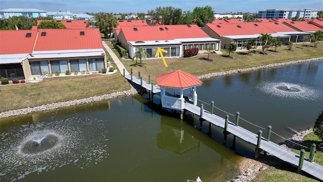 dock area with a lawn, a water view, and boat lift