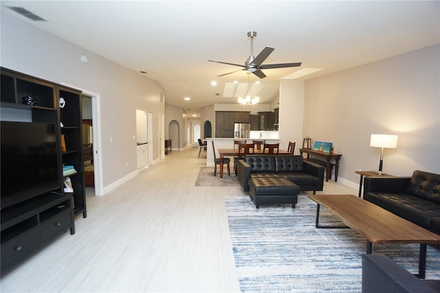 living area featuring a ceiling fan, baseboards, visible vents, arched walkways, and light wood-type flooring