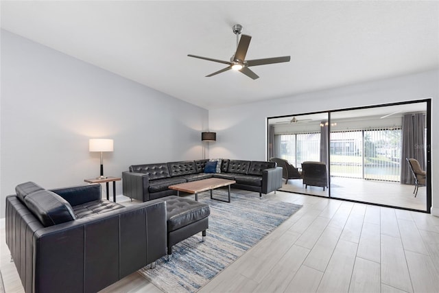 living room with light wood finished floors, ceiling fan, and vaulted ceiling