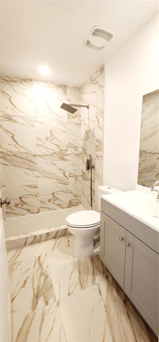 3372 Elkcam Blvd, Port Charlotte, FL 33952 - bathroom featuring vanity, visible vents, tiled shower, toilet, and marble finish floor