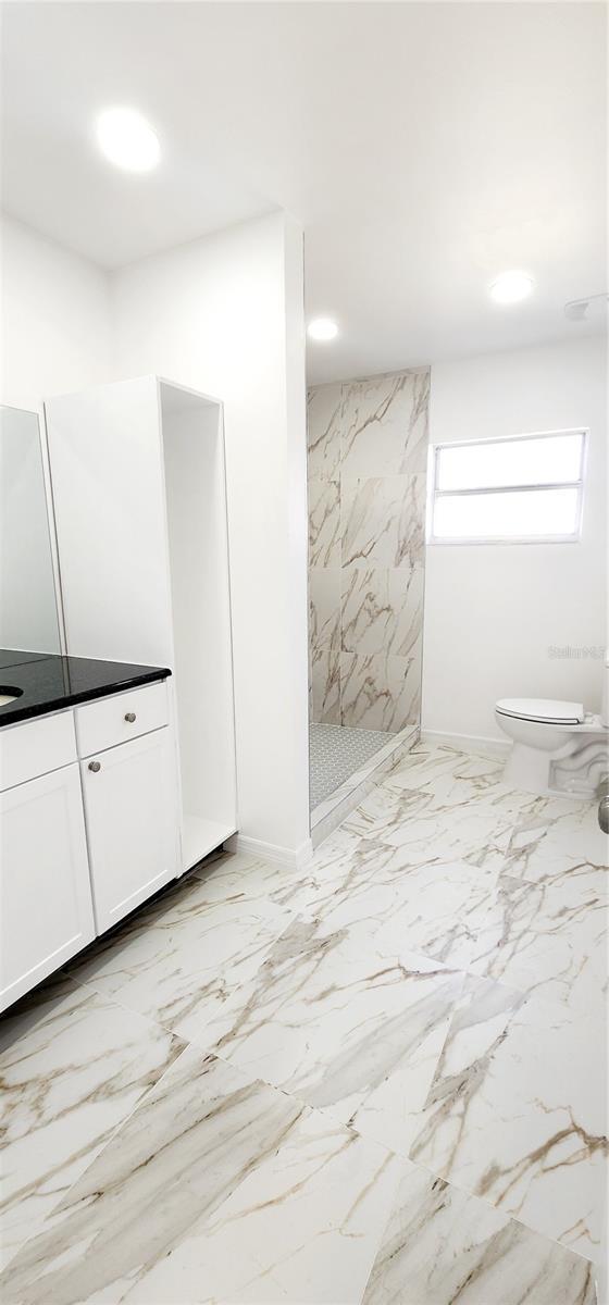 3372 Elkcam Blvd, Port Charlotte, FL 33952 - full bathroom with toilet, marble finish floor, recessed lighting, a marble finish shower, and vanity