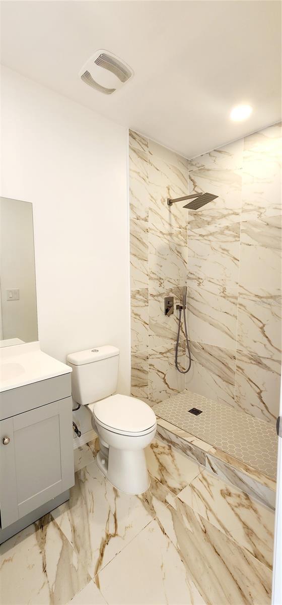 3372 Elkcam Blvd, Port Charlotte, FL 33952 - bathroom featuring visible vents, toilet, marble finish floor, a tile shower, and vanity