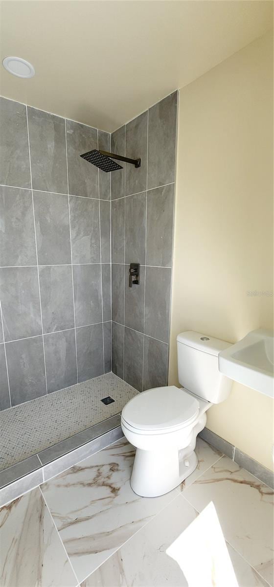 3372 Elkcam Blvd, Port Charlotte, FL 33952 - bathroom featuring tiled shower, toilet, and marble finish floor