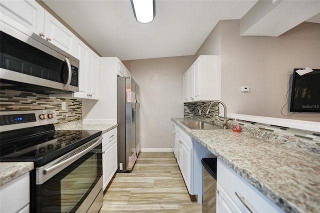 kitchen featuring a sink, stainless steel appliances, tasteful backsplash, and white cabinets