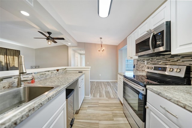 kitchen featuring a sink, lofted ceiling with beams, stainless steel appliances, white cabinets, and decorative backsplash