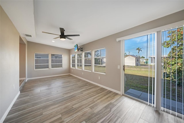 unfurnished sunroom with visible vents, lofted ceiling, and ceiling fan