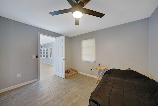 bedroom featuring a ceiling fan, light wood-type flooring, and baseboards