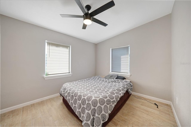 bedroom with baseboards, lofted ceiling, a ceiling fan, and light wood finished floors