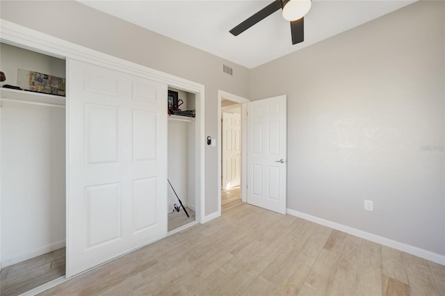 unfurnished bedroom featuring visible vents, baseboards, ceiling fan, light wood-style flooring, and a closet