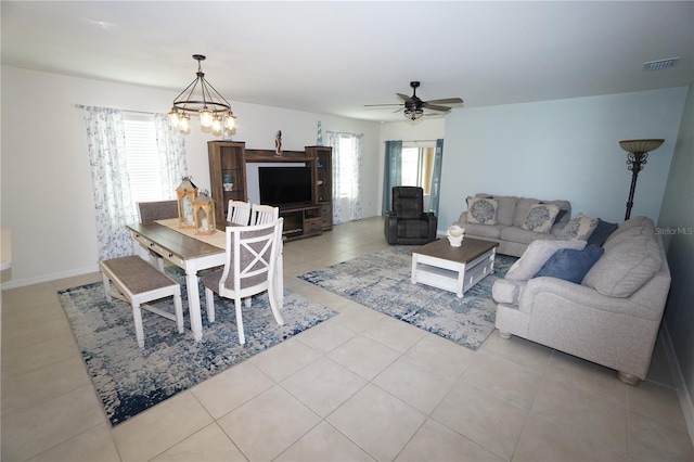 living room with light tile patterned flooring, ceiling fan with notable chandelier, and visible vents