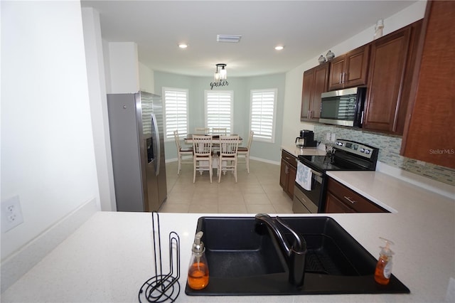 kitchen featuring light tile patterned floors, visible vents, light countertops, appliances with stainless steel finishes, and backsplash
