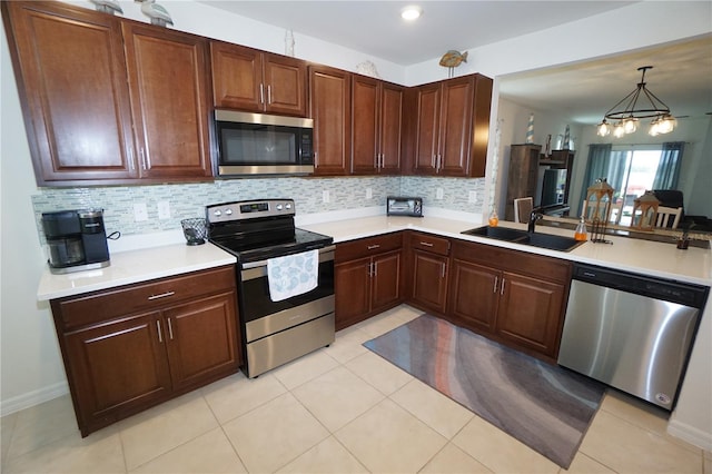 kitchen featuring a sink, tasteful backsplash, stainless steel appliances, light tile patterned flooring, and light countertops