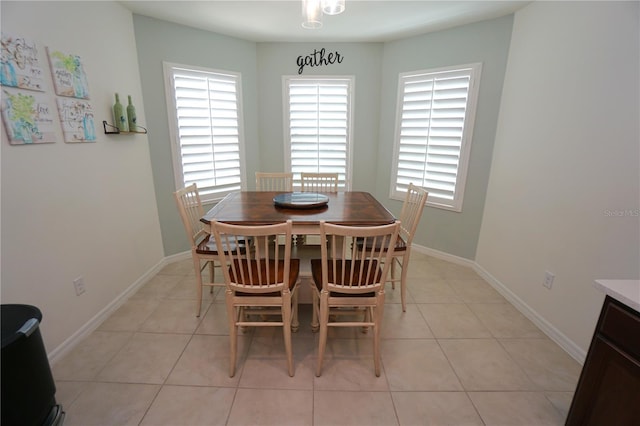 dining space with light tile patterned floors, baseboards, and plenty of natural light