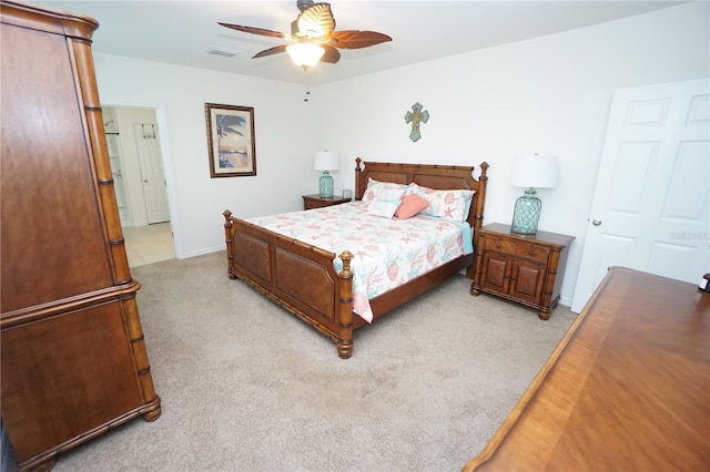 bedroom with visible vents, baseboards, light colored carpet, and ceiling fan