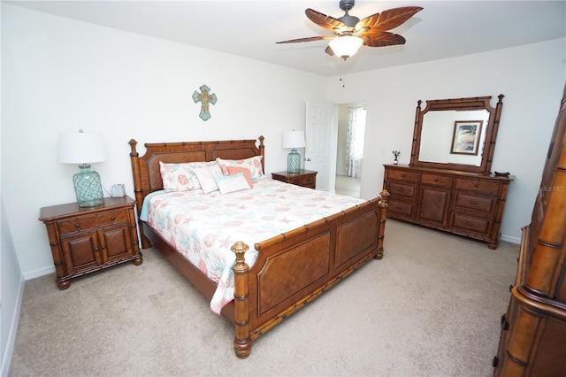 bedroom featuring baseboards, light colored carpet, and ceiling fan
