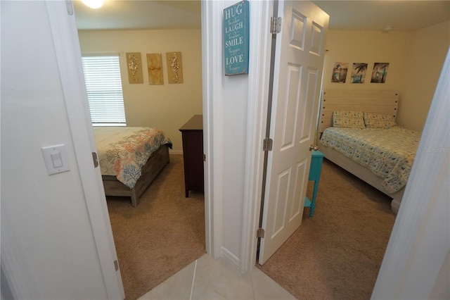 bedroom with light tile patterned floors and light colored carpet