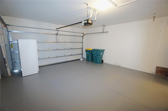 garage with a garage door opener and freestanding refrigerator