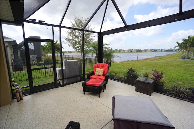 view of patio / terrace with glass enclosure, a water view, and fence