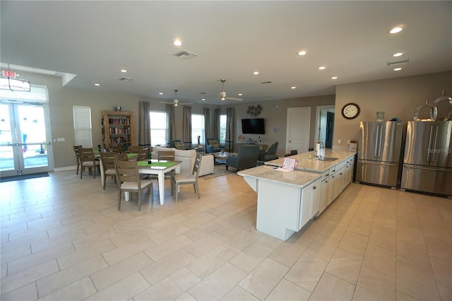 kitchen with recessed lighting, visible vents, freestanding refrigerator, and a sink