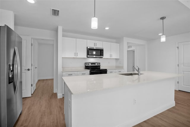 kitchen with a sink, visible vents, light wood-style floors, and appliances with stainless steel finishes