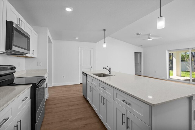 18124 Goliad Ave, Port Charlotte, FL 33954 - kitchen featuring appliances with stainless steel finishes, a sink, dark wood finished floors, vaulted ceiling, and baseboards