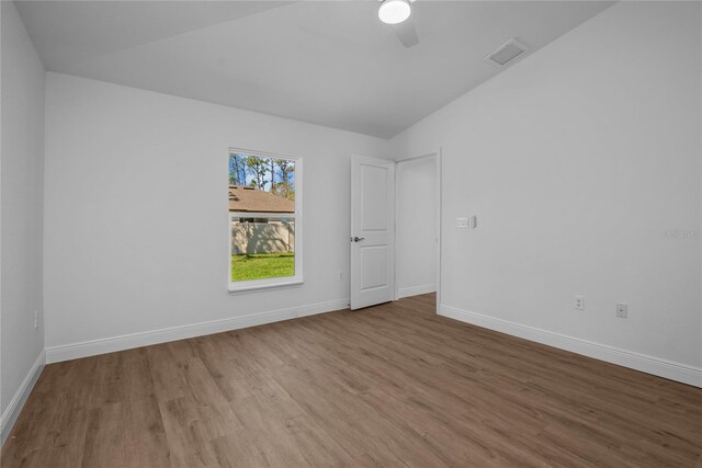 18124 Goliad Ave, Port Charlotte, FL 33954 - empty room featuring wood finished floors, baseboards, a ceiling fan, and lofted ceiling