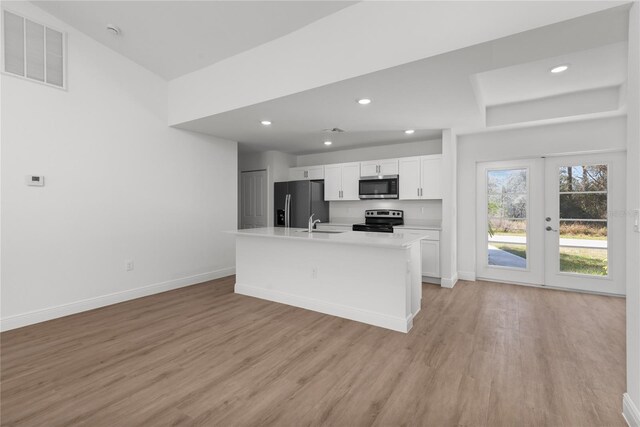 111 Swan Dr, Rotonda West, FL 33947 - kitchen featuring appliances with stainless steel finishes, white cabinets, light wood finished floors, baseboards, and light countertops