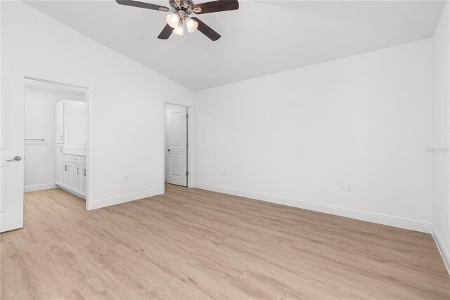 111 Swan Dr, Rotonda West, FL 33947 - unfurnished bedroom featuring vaulted ceiling, baseboards, light wood-style floors, ceiling fan, and connected bathroom