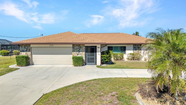 ranch-style house with stucco siding, driveway, stone siding, an attached garage, and a front yard