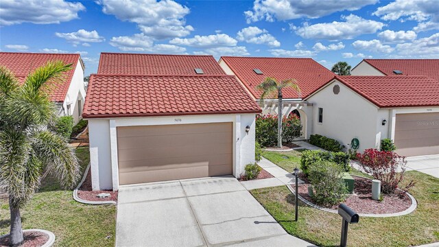 5036 San Rocco Ct, Punta Gorda, FL 33950 - mediterranean / spanish-style house featuring stucco siding, concrete driveway, an attached garage, and a tiled roof