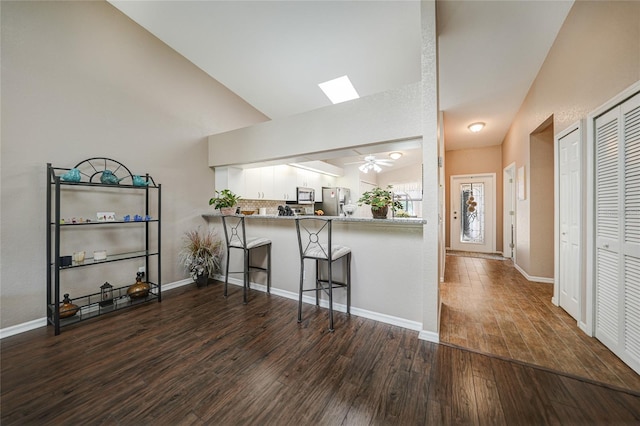 5036 San Rocco Ct, Punta Gorda, FL 33950 - kitchen featuring dark wood-style flooring, ceiling fan, appliances with stainless steel finishes, white cabinetry, and a kitchen breakfast bar