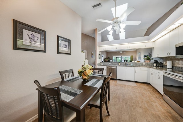 5036 San Rocco Ct, Punta Gorda, FL 33950 - dining space featuring lofted ceiling with skylight, visible vents, light wood-style flooring, and a ceiling fan