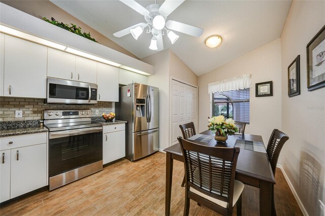 5036 San Rocco Ct, Punta Gorda, FL 33950 - kitchen with light wood finished floors, tasteful backsplash, appliances with stainless steel finishes, and vaulted ceiling