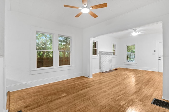 unfurnished living room with visible vents, wood-type flooring, baseboards, and ceiling fan