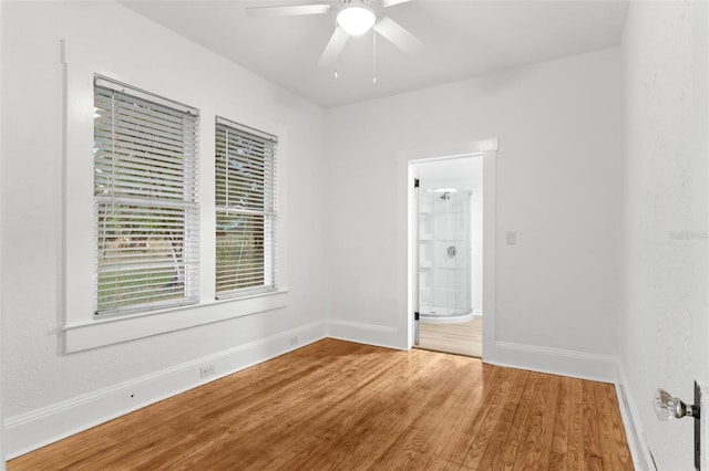 empty room with wood finished floors, baseboards, and ceiling fan