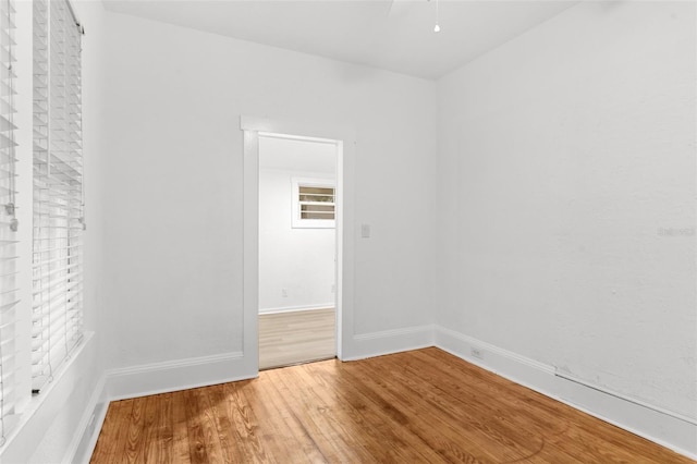 empty room featuring a ceiling fan, wood finished floors, and baseboards