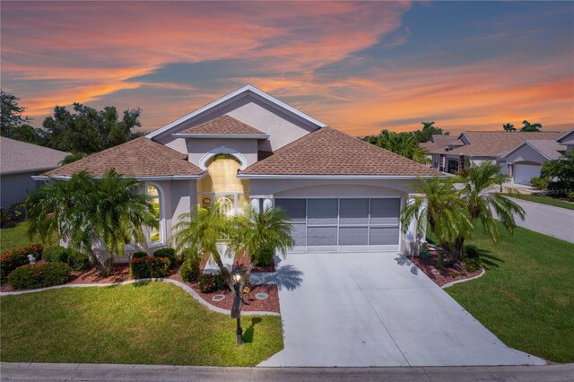 1701 Lastingham Ln, Port Charlotte, FL 33980 - mediterranean / spanish-style house with a front yard, a garage, driveway, and stucco siding