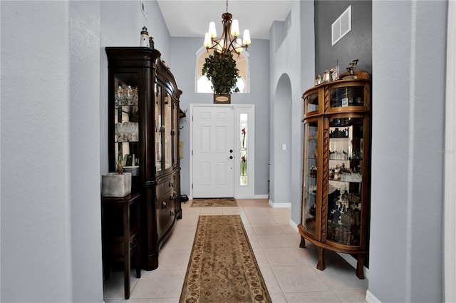 1701 Lastingham Ln, Port Charlotte, FL 33980 - entrance foyer with visible vents, a notable chandelier, arched walkways, light tile patterned floors, and baseboards