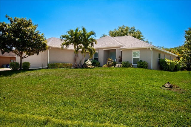 ranch-style home with a front lawn, an attached garage, and stucco siding