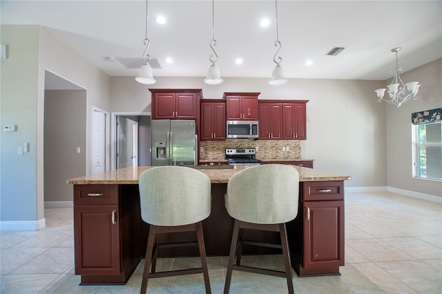 kitchen featuring visible vents, dark brown cabinets, appliances with stainless steel finishes, decorative light fixtures, and backsplash