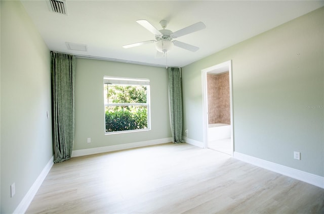 spare room with visible vents, baseboards, wood finished floors, and a ceiling fan