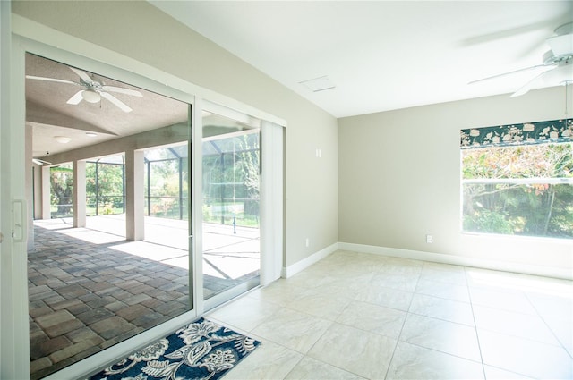 unfurnished room with light tile patterned floors, baseboards, lofted ceiling, and a ceiling fan