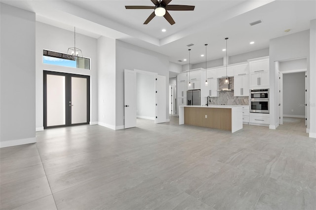 2716 SW 13th Ave, Cape Coral, FL 33914 - kitchen featuring wall chimney range hood, open floor plan, a towering ceiling, and stainless steel appliances
