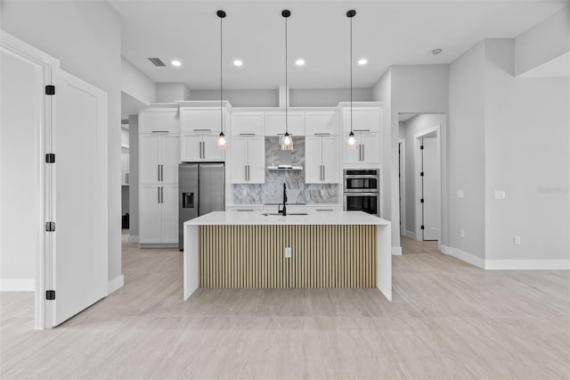 2716 SW 13th Ave, Cape Coral, FL 33914 - kitchen featuring wall chimney range hood, a center island with sink, light countertops, white cabinets, and stainless steel appliances